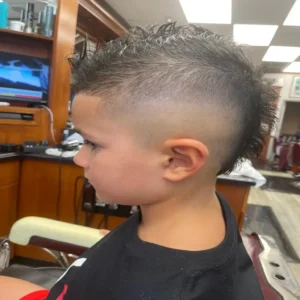 barber preparing to style a client’s hair with professional tools