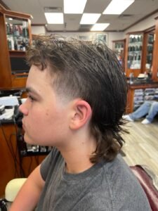 Client receiving a haircut in a classic barber chair