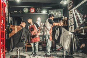 A barber styling a customer's hair using a comb and scissors