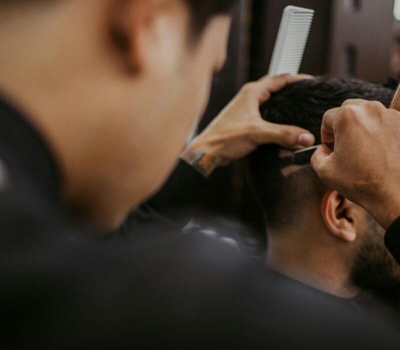 A barber consulting with a client about a hairstyle
